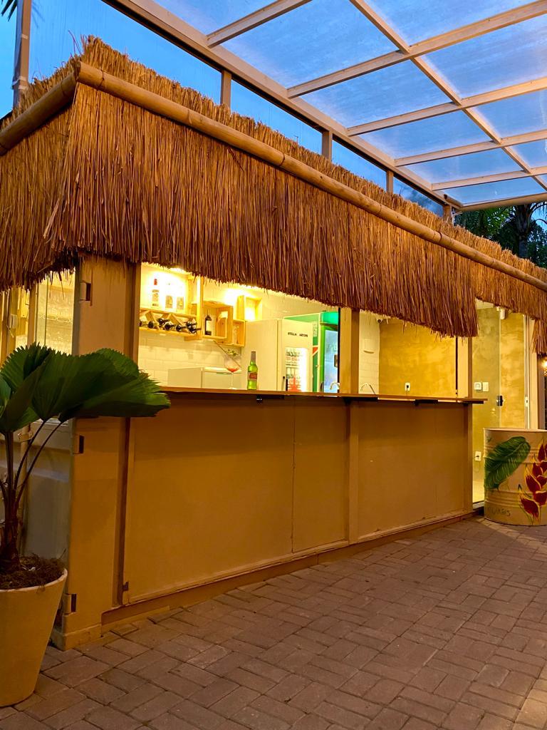 Bar coberto com telhado de palha ao entardecer